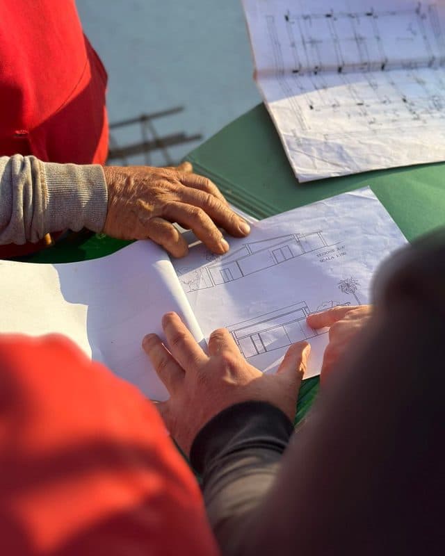 Hands on a set of drawings as a crew plans the work