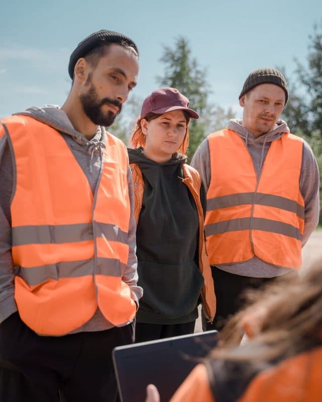 A crew in high-visibility vests gathered for a talk before work